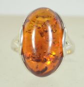 A silver 925 ladies dress ring with a central amber cabochon stone Ring size M weighs 3.7 grams.