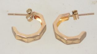 A pair of 9ct gold hoop earrings with etched star decoration and post backs. Tests 9ct gold.