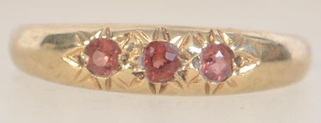 A hallmarked 9ct gold ring set with orange stones in star settings. Hallmarked London. Maker M.J.