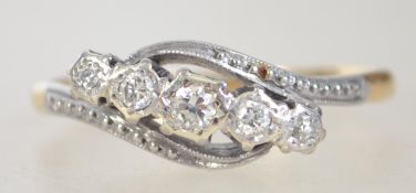 An 18ct gold platinum and diamond 5 stone ring in a cross over design. The diamonds approx 20pnts.