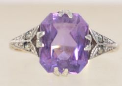An Art Deco 9ct gold and silver ring set with a large purple faceted stone with marcasite set