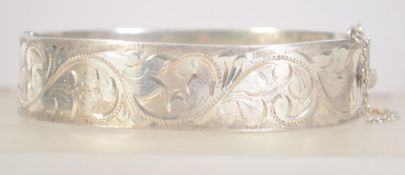 A vintage hallmarked 925 silver bangle bracelet with foliate engraving.