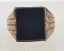 A 1970's gentlemans 9ct gold signet ring with inset square black glass stone.