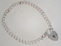 A vintage silver chain bracelet with heart lock. Marked Silver. Measures 8 inches.