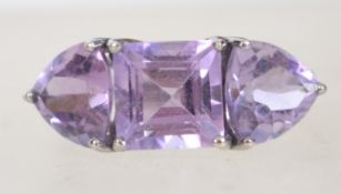 A hallmarked 9ct white gold and trilogy amethyst ring.