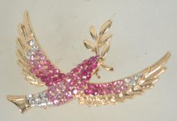 A vintage rhinestone set gold tone figural brooch in the form of a dove of peace carrying an olive