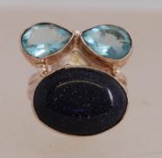 A white metal ring set with goldstone and aqua glass. Size P.