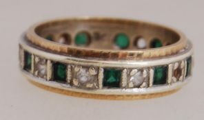 A 9ct gold band ring set with white and green stones. Marked 9ct. Total weight 4.1g. Size L.