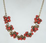 A vintage red glass berry cluster festoon necklace with hook clasp. Measures 16 inches.