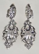A pair of white metal clip on drop earrings. Measures 5.5cms.