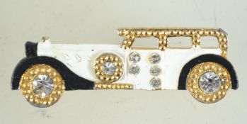A 1970s enamel and rhinestone goldtone brooch in the form of a 1920s limousine with rollover catch.