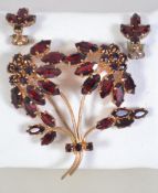 A vintage rhinestone set weeping flower brooch and earring suite set with marquise and round cut