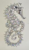 A silver tone figural brooch pin in the form of a seahorse set with AB rhinestones with roller clip