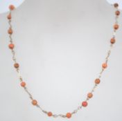 A vintage rolled gold and coral bead necklace with hook clasp. Measures 16 inches.