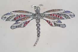 A vintage rhinestone set silver tone figural brooch in the form of a dragonfly with roller clip