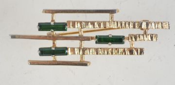A 1960s Modernist goldtone brooch set with green baguette rhinestones and rollover catch.