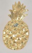 A vintage gold tone figural brooch in the form of a pineapple with safety clip clasp.