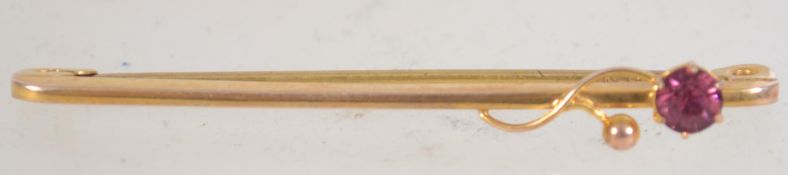 A Edwardian 9ct gold bar brooch with entwined flower and central set stone with c clasp.
