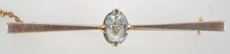 An Art Deco 15ct gold bar brooch with oval cut aquamarine stone with C clasp and safety chain.