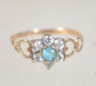A 9ct gold cluster ring set with CZ and central blue stone. Marked 375 Optima CZ 9ct. Tests 9ct.