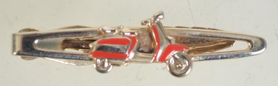 A 1960s tie clip in gold tone metal in the form of a scooter marked Nippy Clip Made in England.