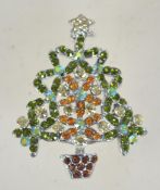 A vintage rhinestone Christmas tree brooch in silvertone metal with a roll over catch. Measures 4.