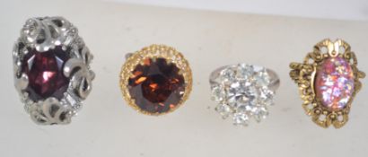 Four vintage white and yellow metal rings with adjustable sizes,