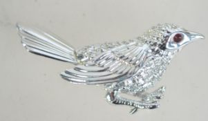 A vintage Sarah Coventry silver tone figural brooch in the form of a Wren bird with red rhinestone