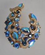 A vintage peacock blue AB rhinestone set brooch pin signed Sphinx with roller clip clasp.