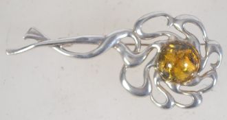 A vintage silver and Baltic amber brooch bearing Russian hallmarks with loop catch. Measures 5.