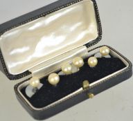 A collection of 6 white metal and pearl shirt studs in a vintage box.