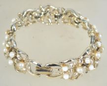 A vintage Jewelcraft white metal bracelet set with pearls and stylized flowers with clip clasp.