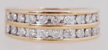 A 9ct gold and diamond band ring set with round cut diamonds within twin channels. Total weight 5.