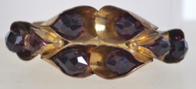 An Art Deco bangle clamper bracelet with Greek key decoration to band with large stylized lilies