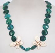 A turquoise style bead necklace with butterfly bead pendants and stylized white metal toggle clasp.