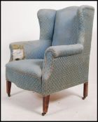 An Edwardian mahogany wing back armchair