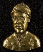 A brass relief plaque of the jockey Fred Archer, mounted on a backboard for wall mounting,