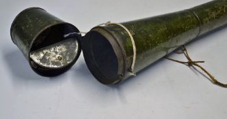 Military Type Metal carrier with long thing cylindrical body and thicker end, opens with a hinged
