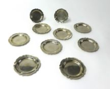 A set of eight metal petal dishes stamped 0900 and two similar smaller examples weight 28oz.
