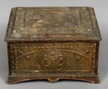 A 19th century carved box The hinged lid and sides with Gothic style panels with cherub masks.