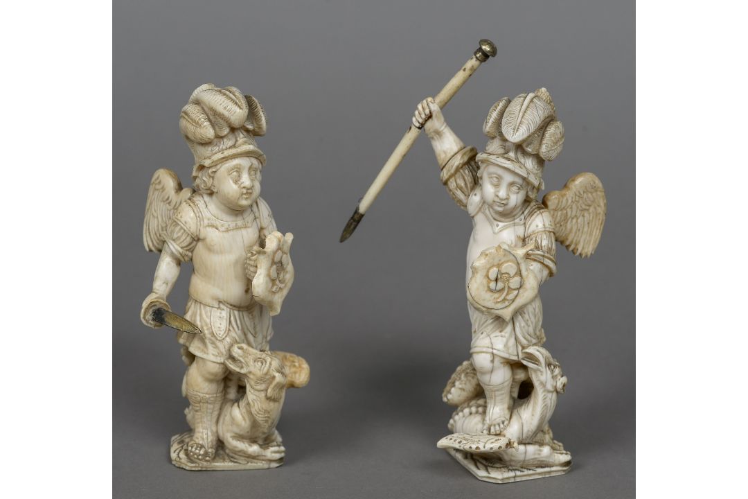 A pair of 18th/19th century Dieppe carved ivory figures Each formed as a cherub fighting a dragon.