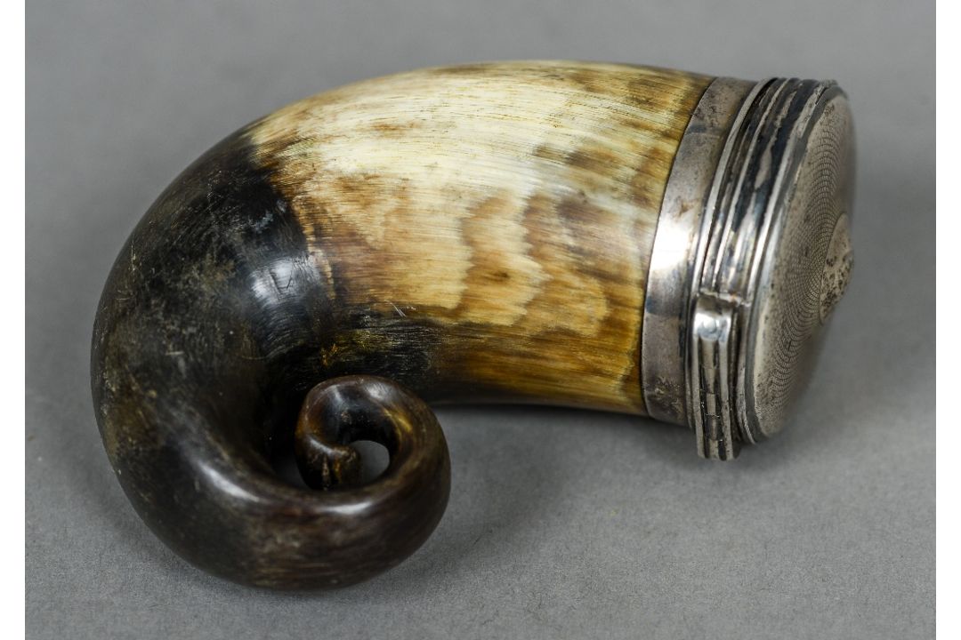 A Scottish unmarked white metal mounted horn snuff mull Of typical hinged form. 8 cm high.