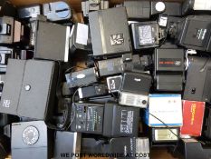 A box of mixed flash units including Nikon, Canon,