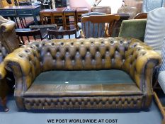 A faux leather Chesterfield sofa and wing backed arm chair