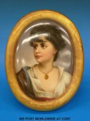 A KPM convex plaque decorated with a head and shoulders portrait of a pretty girl (27cm in length)