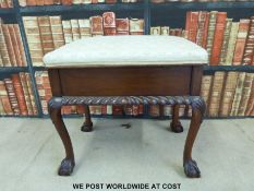 A Victorian or early 20th century carved mahogany piano stool raised on ball and claw feet