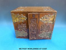 A small carved oak and brass hinged cabinet opening to reveal two drawers with brass handles within,