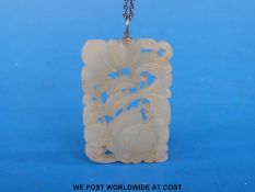 A white jade nephrite pendant carved with floral decoration