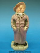A Royal Worcester figure of a man in long coat and hat (14cm tall)