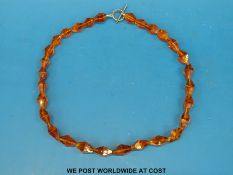 An amber necklace of 29 faceted translucent beads
